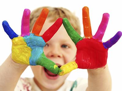 Little boy with colorful paint on this hands 